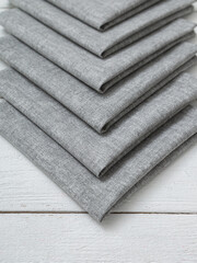 Grey napkins on a wooden white background.