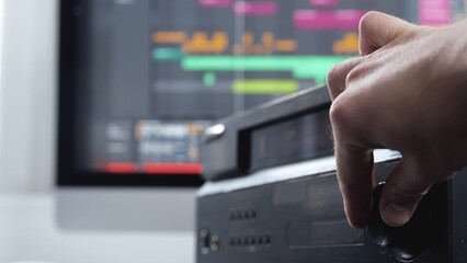 Young man in sound recording studio. Cut view video of male's hand Close up hands changing volume....