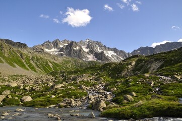 Beautiful mountain landscape with a river and snow, tour of the Ecrins and Oisans Massif, hiking, trek, GR54, Alps, France, summer, holidays.
