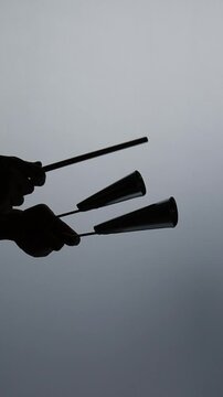 silhueta de  homem tocando instrumento agog&ocirc; 