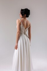Elegant bridal gown showcase in a minimalist studio setting highlighting intricate back design in soft natural light
