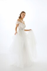 Fototapeta premium Elegant bride in white gown gracefully poses for a fashion shoot in a studio setting