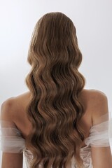 Elegant long wavy hair styled beautifully with intricate waves in minimalistic setting