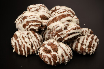 Profiteroles with coconut cream on a black background.