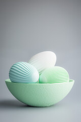 Easter decoration. Colorful eggs in bowl on grey background.