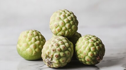 Fototapeta premium Closeup of Four Green Cherimoya Fruits on Marble Background