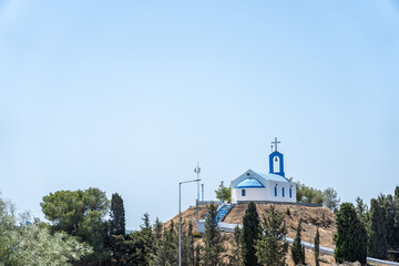 Traditionally white and blue chapel on hill overlooking airport at Antimachia