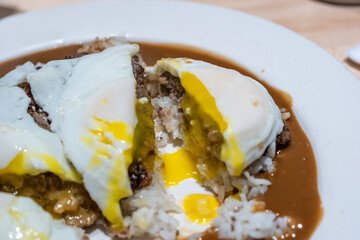 Hawaiian loco moco with rice, hamburger patty, brown gravy, and two over-easy eggs