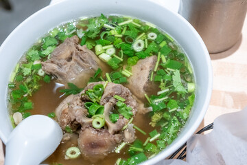 Overhead shot of Oxtail Soup with broth and green onion and cilantro
