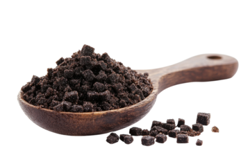 Black sugar in a wooden spoon with granules scattered around in a bright kitchen