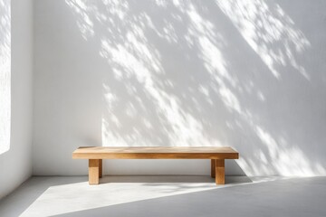 Wooden bench with sunlight casting shadows on a minimalist wall in a serene indoor space