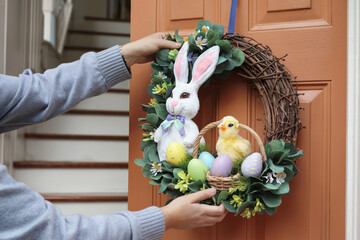 Decorative Easter wreath featuring a bunny, chick, and colorful eggs on a front door