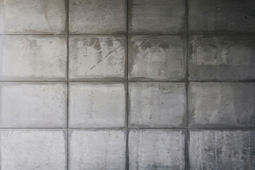 Fototapeta premium Concrete wall with uniform tiles showcasing a modern minimalist design in a contemporary space