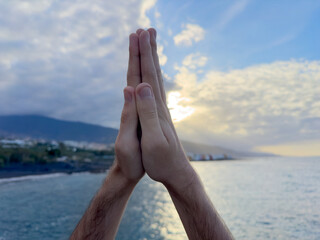 Christian prayer. Man on his knees praying on sunset background. Kneeling prayer to God.