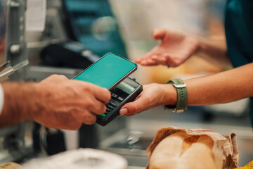 Customer paying with smartphone nfc in grocery store