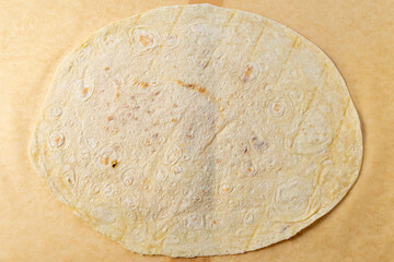 Handmade tortilla on parchment paper ready for filling