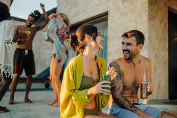 Friends enjoying drinks and dancing at a luxurious summer pool party