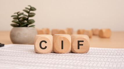 wooden blocks spelling "CIF" on financial documents, representing international trade and logistics