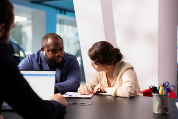 Car sales executive helping couple make decision when choosing what type of vehicle to invest in....