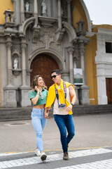 Fototapeta premium Tourists holding hands and crossing the street in front of a church