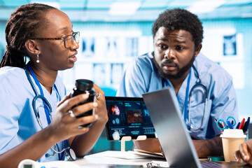General practitioner and junior nurses in a cabinet discussing about drugs and painkillers to...