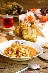 Lebaran Menu, Ketupat, Lontong accompanied by side dishes of Vegetable Soup, Tofu, Rambak and Potatoes with red syrup drink, a typical dish during Eid al-Fitr in Indonesia
