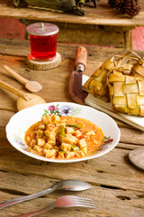 Vertical Photo of menu Lebaran ketupat, lontong and vegetable soup tofu rambak, potatoes with red syrup drink. Ketupat is a typical dish during Eid al-Fitr in Indonesia