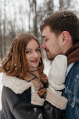 Fototapeta premium A couple joyfully embracing in a snowy winter wonderland, surrounded by natures beauty