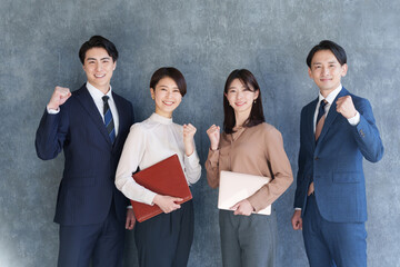 ガッツポーズでカメラ目線のビジネスマン男女複数人