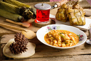 Lebaran Menu, Ketupat, Lontong accompanied by side dishes of Vegetable Soup, Tofu, Rambak and Potatoes with red syrup drink, a typical dish during Eid al-Fitr in Indonesia