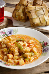 Vertical Photo of menu Lebaran ketupat, lontong and vegetable soup tofu rambak, potatoes with red syrup drink. Ketupat is a typical dish during Eid al-Fitr in Indonesia