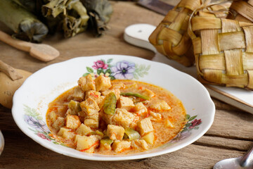 Close up of tofu rambak vegetables, potatoes with red syrup drink. Tofu vegetables are a side dish for Ketupat, a typical dish during Eid al-Fitr in Indonesia.