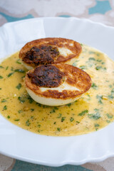 Les Oeufs Jeannette (Eggs Jeannette) with special filling and yellow sauce, vegetarian food