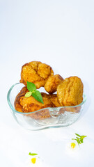 Fried salted tofu with leaf garnish in clear mini bowl isolated on white