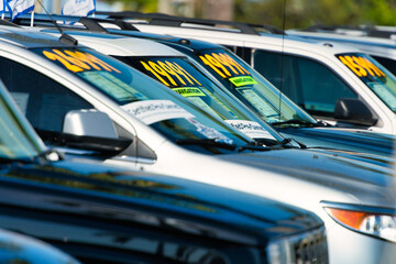 Used cars lined up on a pre-owned auto dealership lot
