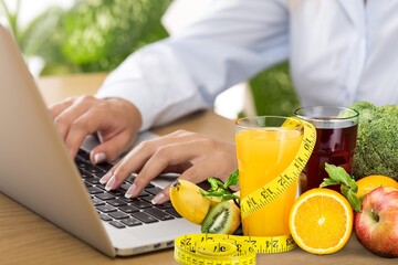 Young nutritionist working on laptop at table in office,