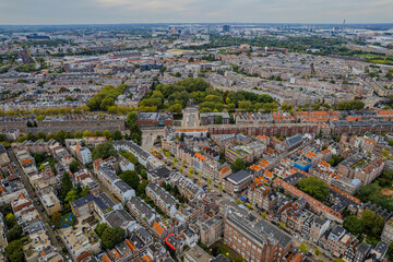 Aerial view of Amsterdam, Netherlands showcases its iconic canal houses, Dutch architecture, and boat tours along the waterfront, capturing the charm of this historic European cityscape