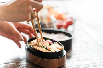 キッチンでお弁当を詰める女性の手元（愛妻弁当）
