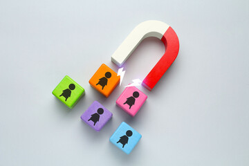Magnet attracting colorful cubes with human figures on light grey background. Recruitment or...