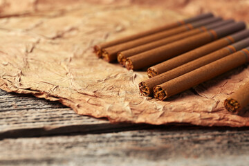 Dried tobacco leaf and cigarettes on wooden table, closeup