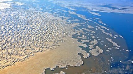 Naklejka premium Aerial View of Frozen River Ice Patterns Winter Landscape