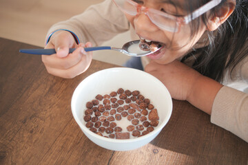 Child enjoys cereal at home during morning meal time
