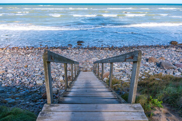 A scenic coastal landscape in Hirtshals, Denmark, with clear blue skies, soft sandy dunes, and the...