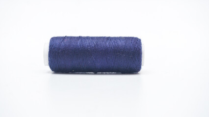Close up blue navy spool of sewing thread isolated on white background