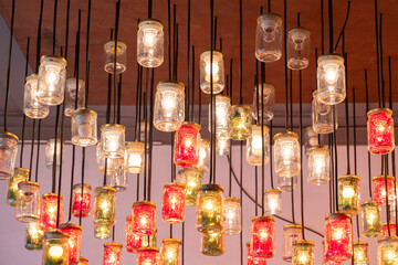 Decorative ceiling lights made of many upcycled repurposed glass jars with light bulbs installed. Recycling and hand made home decoration concept.