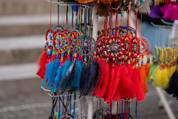Many colorful hand made dream catcher souvenirs made of leather, feathers and beads hanging at the...