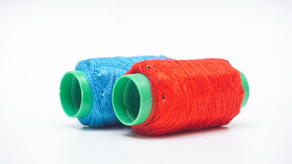 Light blue and red spool of sewing thread isolated on white background