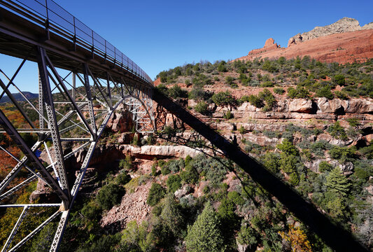 Bridge in valley with red rocks and a large shadow