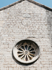 Rose window on the stone wall of an old church