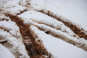 Muddy tire tracks in the snow
